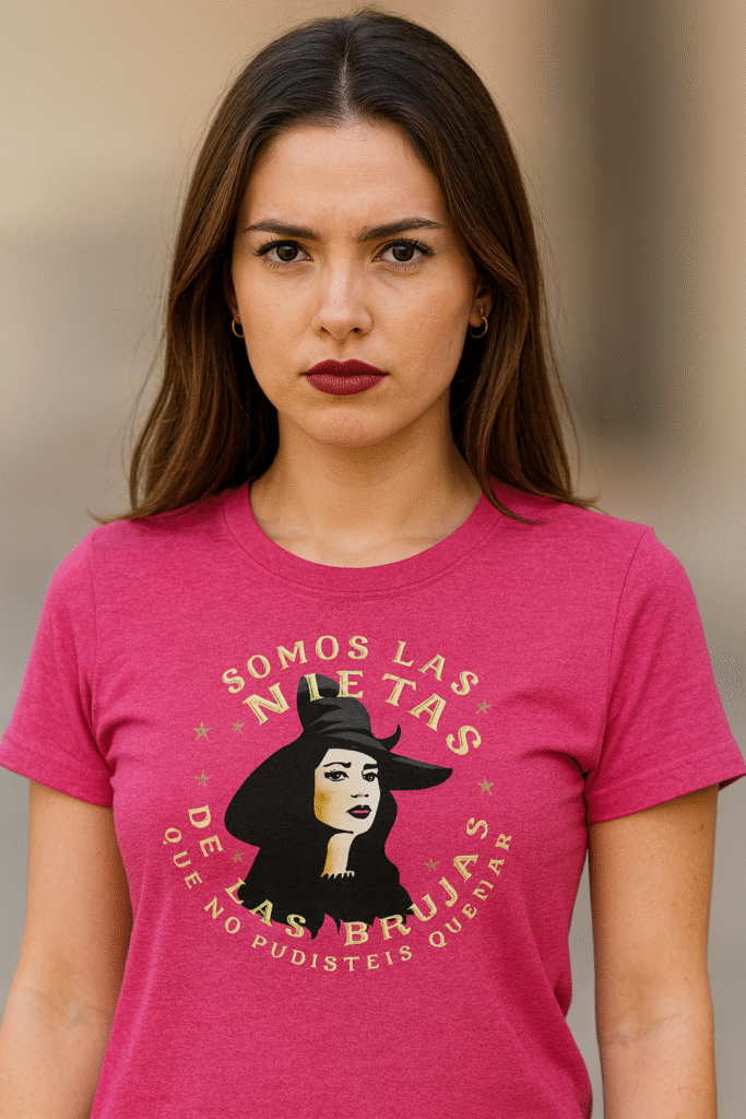 Mujer joven en plano medio con actitud reivindicativa vistiendo camiseta rosa con la frase “Somos las nietas de las brujas que no pudisteis quemar”, parte de la colección de camisetas góticas y alternativas